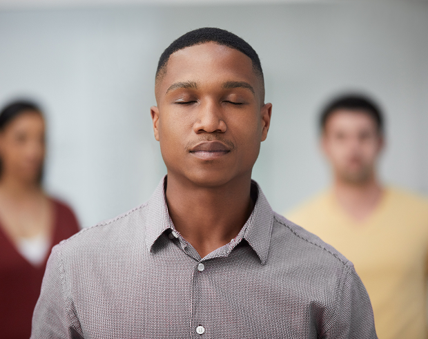 GettyImages-1137985922 A man with his eyes closed in front of two other men.
