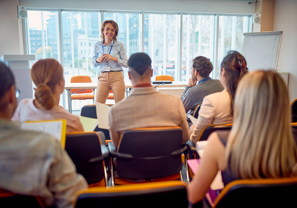 A woman standing in front of a group of people.