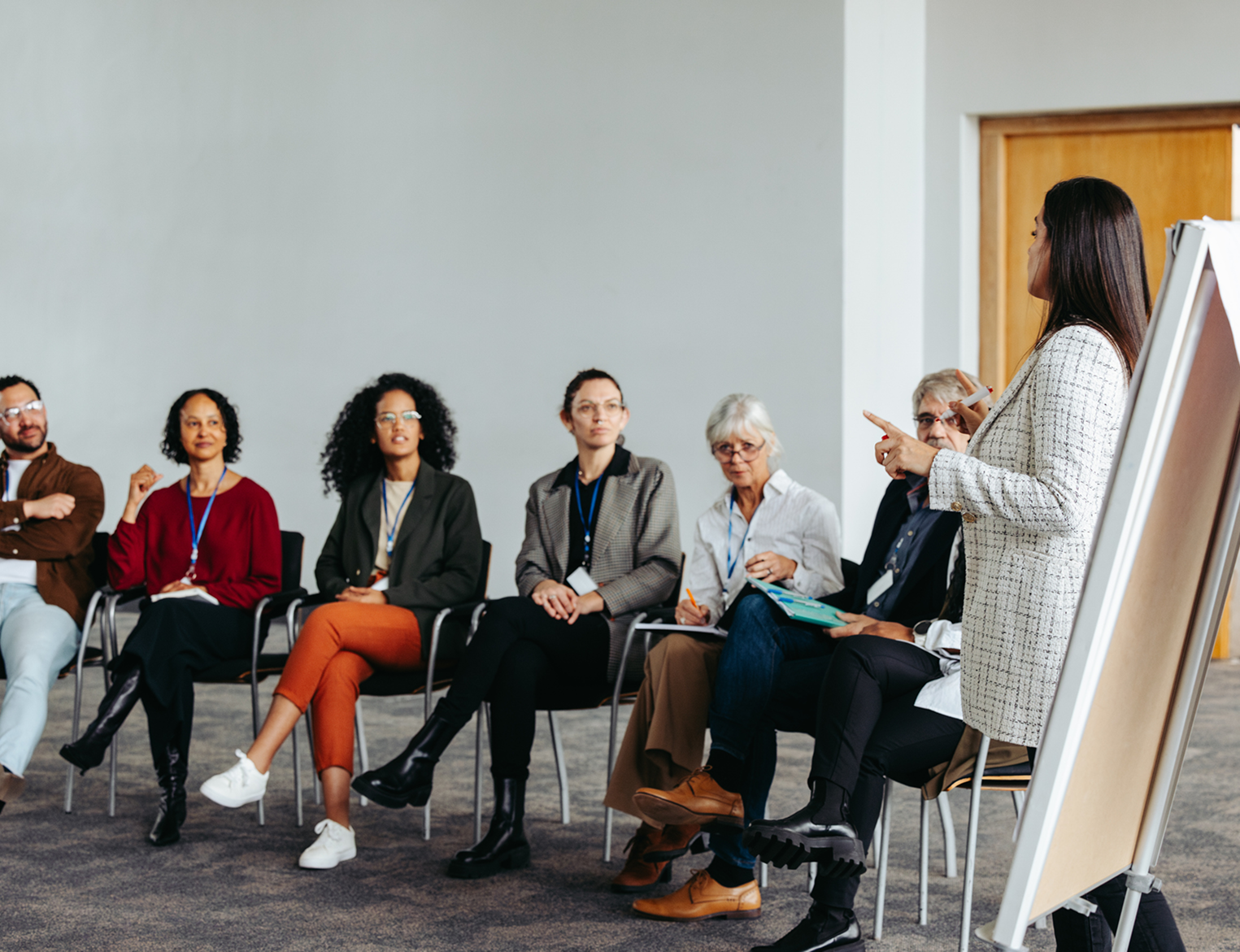 A group of people sitting in chairs and one person standing up.